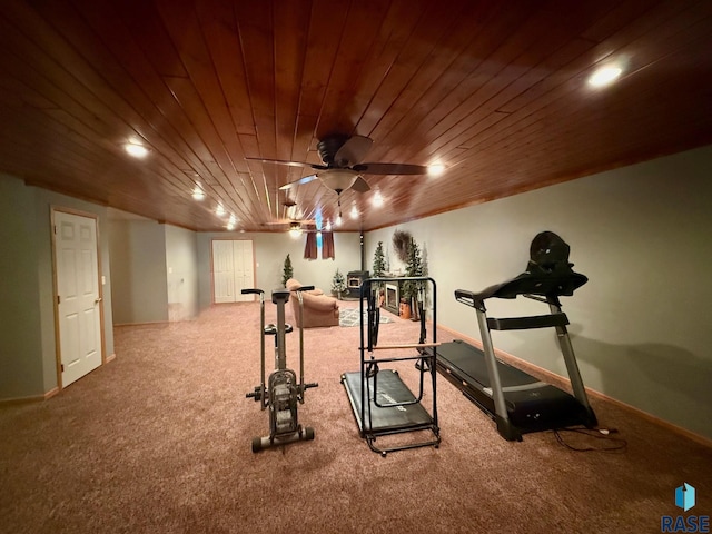 workout room featuring baseboards, carpet flooring, wood ceiling, and a ceiling fan