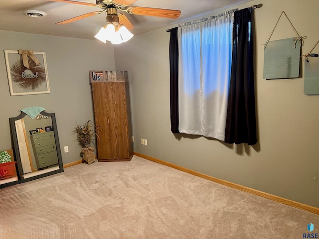 unfurnished bedroom featuring light carpet, baseboards, visible vents, and a ceiling fan