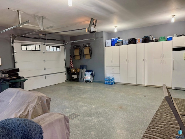 garage with a garage door opener and freestanding refrigerator