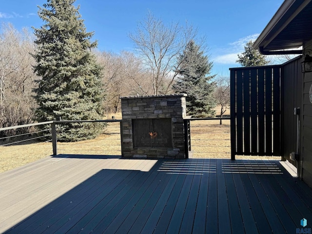 wooden terrace featuring an outdoor stone fireplace