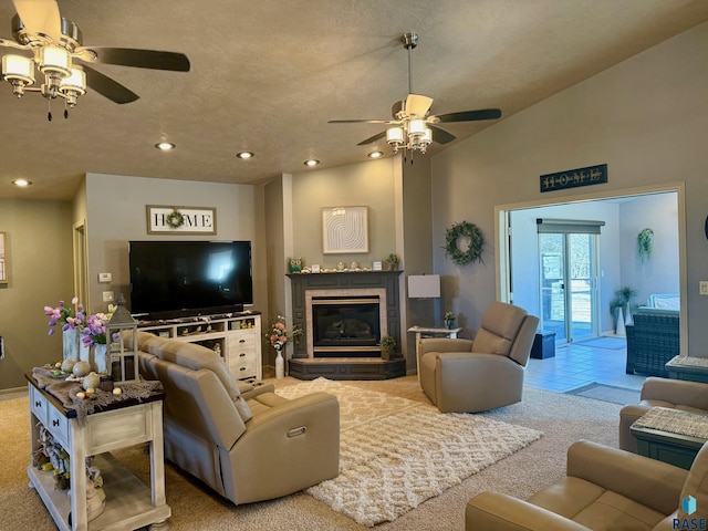 living room featuring a textured ceiling, vaulted ceiling, a tiled fireplace, and carpet flooring