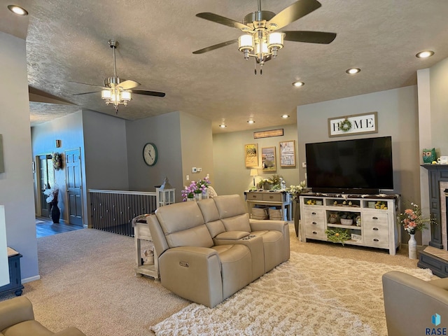 living area with recessed lighting, light colored carpet, ceiling fan, and a textured ceiling