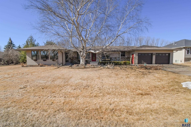 ranch-style home with a garage and aphalt driveway