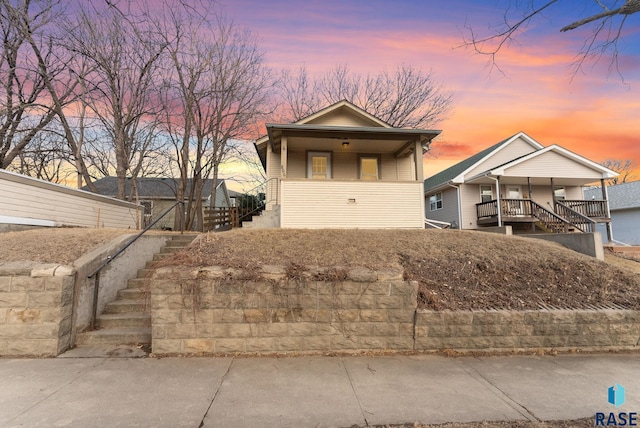 view of front of house featuring covered porch and stairway