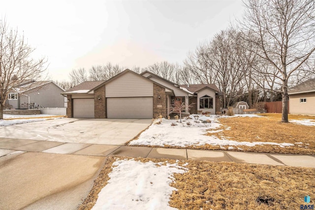 view of front facade featuring a garage, concrete driveway, brick siding, and fence