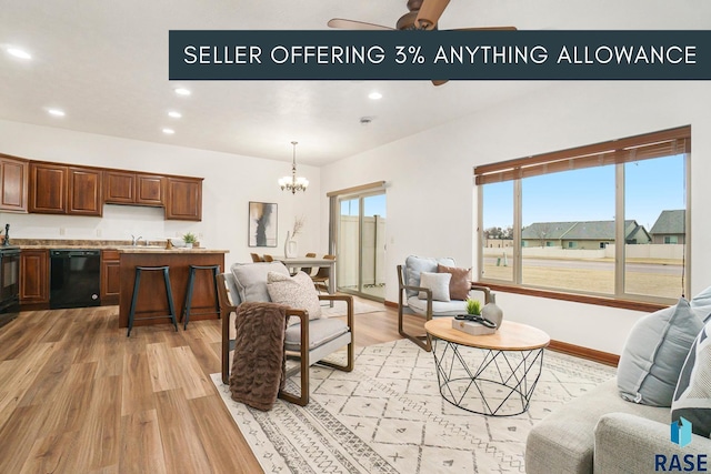 living room with light wood-type flooring, baseboards, ceiling fan with notable chandelier, and recessed lighting