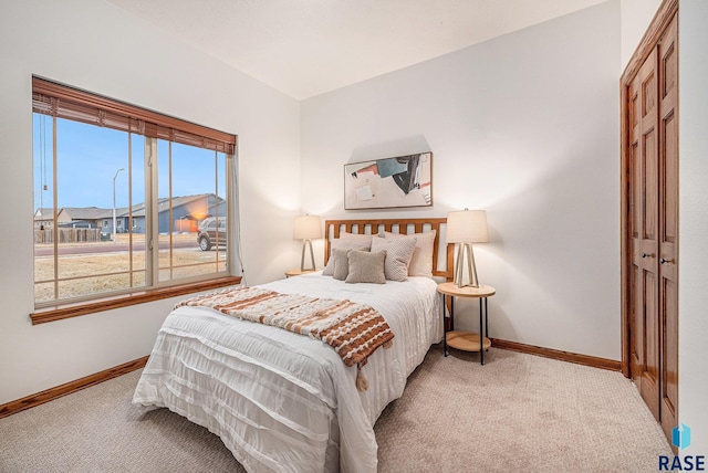 bedroom featuring baseboards and light colored carpet