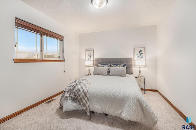 bedroom featuring baseboards, visible vents, a textured ceiling, and carpet flooring