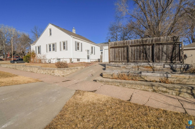 exterior space with a garage, driveway, and a chimney