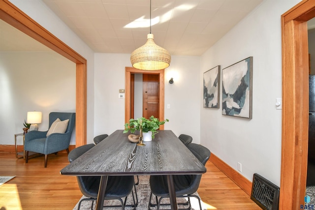 dining room with light wood-type flooring and baseboards