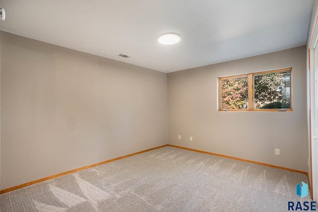 carpeted empty room with visible vents and baseboards