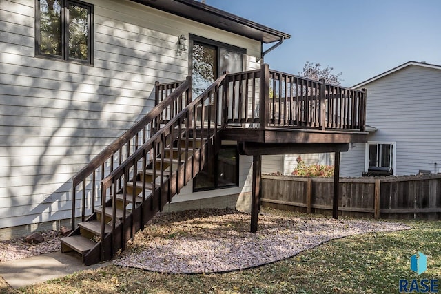 view of exterior entry with fence and a wooden deck