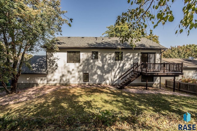 rear view of property with a yard, a shingled roof, fence, a wooden deck, and stairs