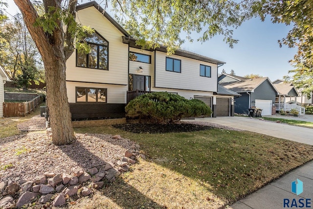 raised ranch with a garage, driveway, and a front lawn