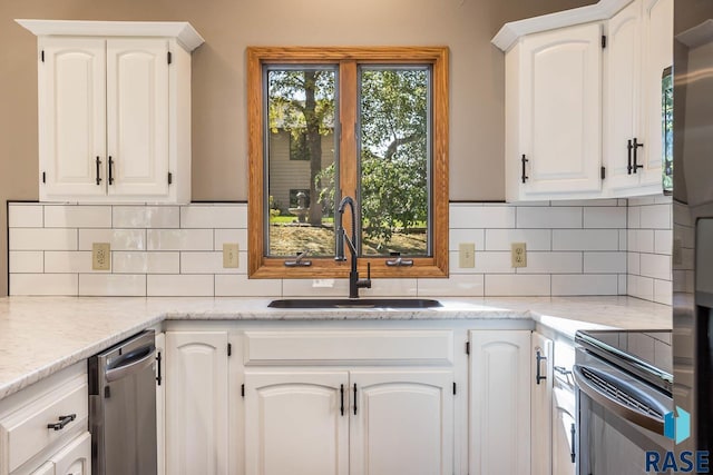 kitchen with light stone counters, a sink, white cabinetry, electric stove, and backsplash