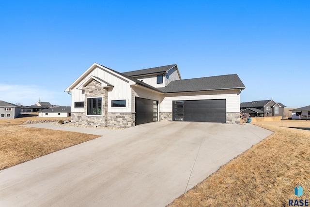 view of front facade with stone siding, board and batten siding, an attached garage, and driveway