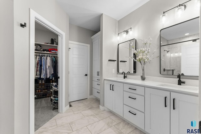 full bath with double vanity, marble finish floor, a shower stall, and a sink