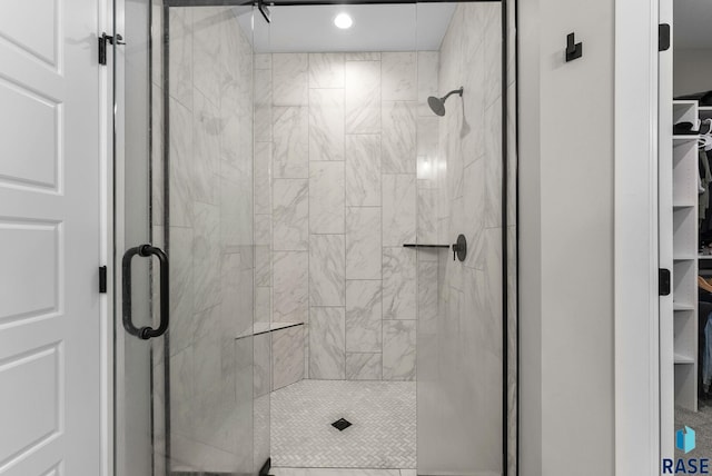 bathroom with a shower stall, a walk in closet, and recessed lighting