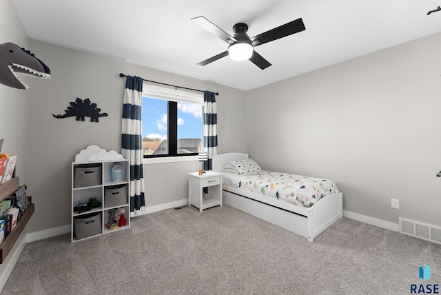 carpeted bedroom featuring a ceiling fan, visible vents, and baseboards