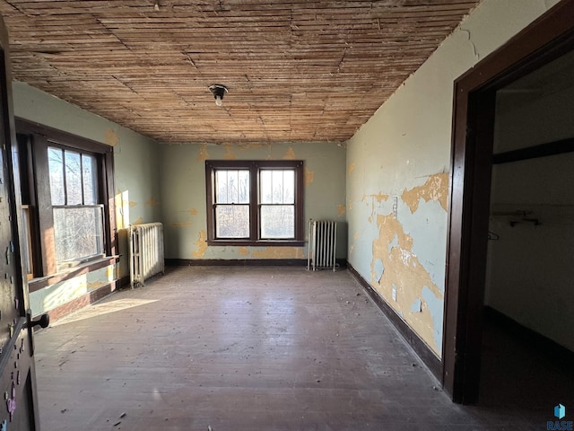 misc room with wood ceiling, radiator, and baseboards