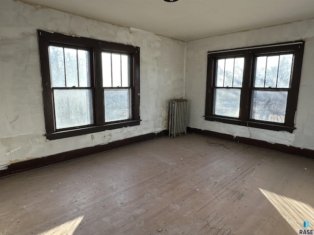 spare room featuring hardwood / wood-style floors and radiator heating unit