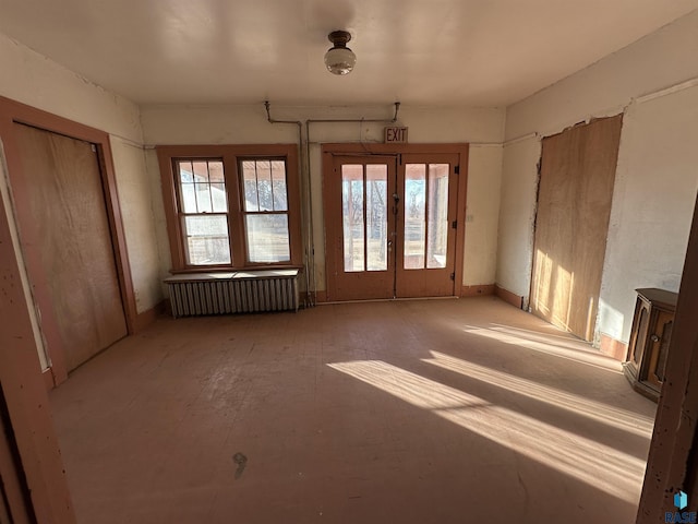 spare room featuring french doors and radiator