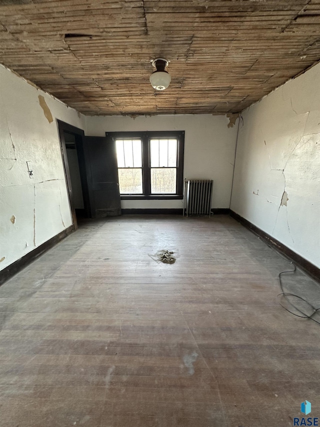 spare room with wooden ceiling, radiator heating unit, and baseboards