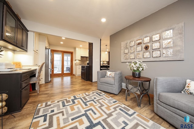 living area featuring light wood-type flooring, french doors, and recessed lighting