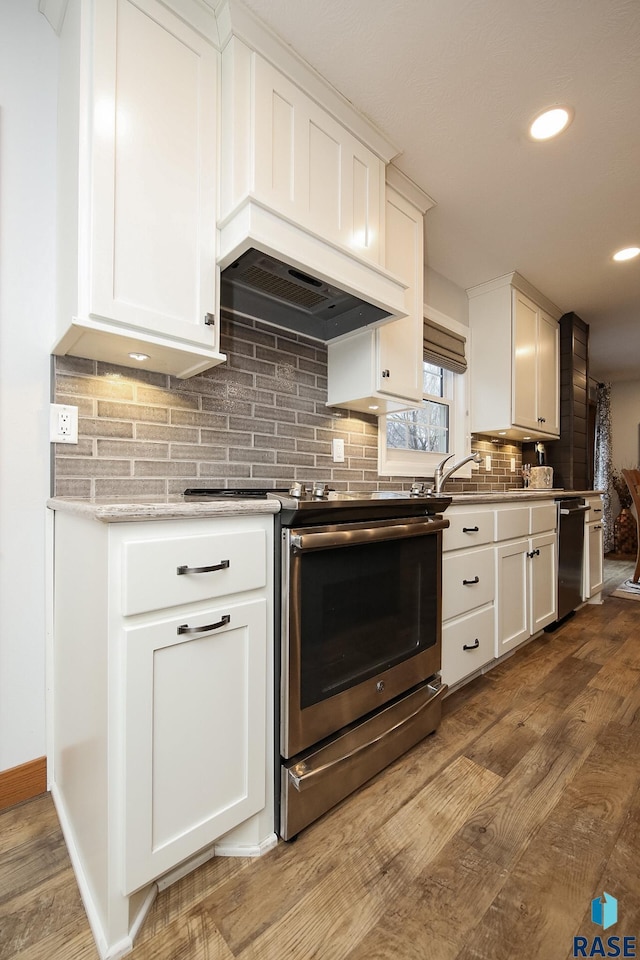 kitchen featuring dark wood-style flooring, custom exhaust hood, tasteful backsplash, appliances with stainless steel finishes, and white cabinetry