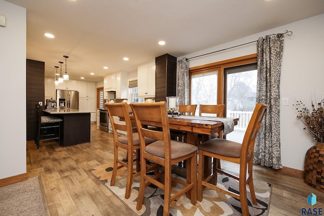 dining room with light wood-type flooring, baseboards, and recessed lighting