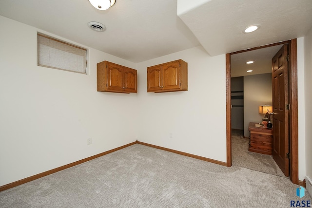 spare room featuring recessed lighting, light colored carpet, visible vents, and baseboards