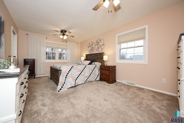 bedroom featuring baseboards, multiple windows, visible vents, and light colored carpet