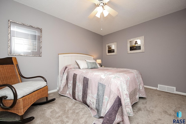 bedroom with baseboards, visible vents, a ceiling fan, a textured ceiling, and carpet floors