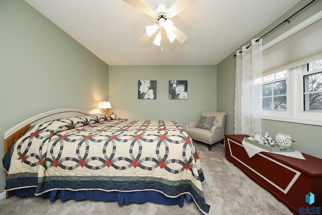 bedroom with ceiling fan, a textured ceiling, and carpet flooring