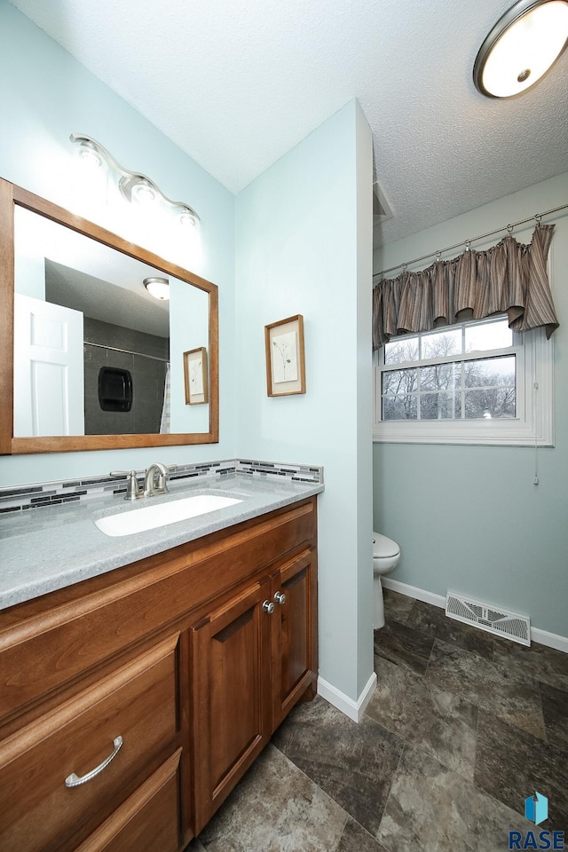 bathroom featuring baseboards, visible vents, toilet, curtained shower, and vanity