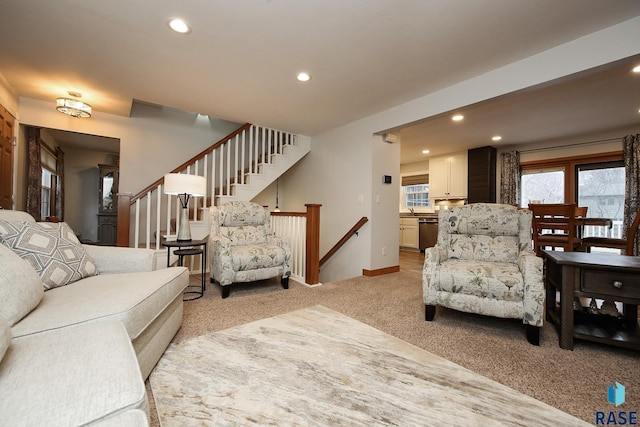 living room featuring light carpet, stairs, baseboards, and recessed lighting