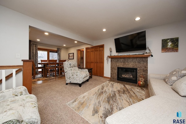 living room featuring carpet, beam ceiling, a tiled fireplace, and recessed lighting