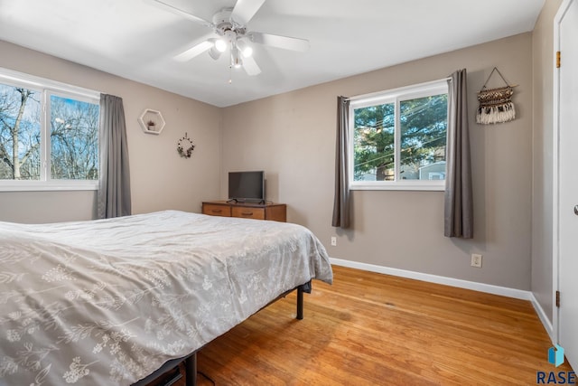 bedroom with wood finished floors, a ceiling fan, and baseboards