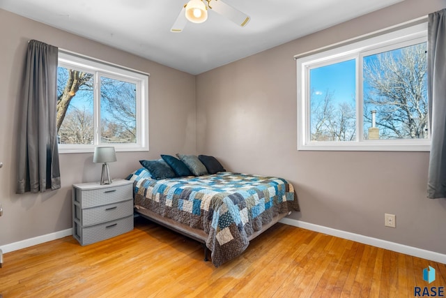 bedroom with baseboards, ceiling fan, and light wood finished floors