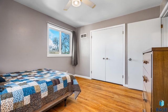 bedroom with a ceiling fan, baseboards, visible vents, and light wood finished floors