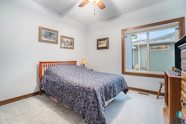 carpeted bedroom with baseboards, visible vents, and a ceiling fan