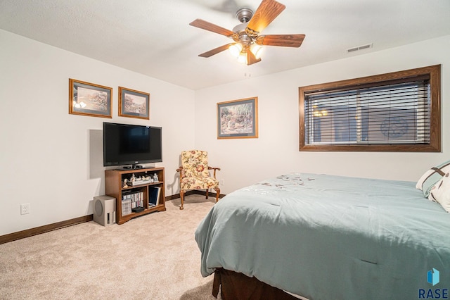 bedroom with light colored carpet, ceiling fan, visible vents, and baseboards