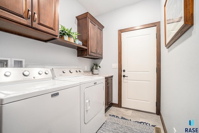 clothes washing area featuring washer and dryer, cabinet space, visible vents, and baseboards