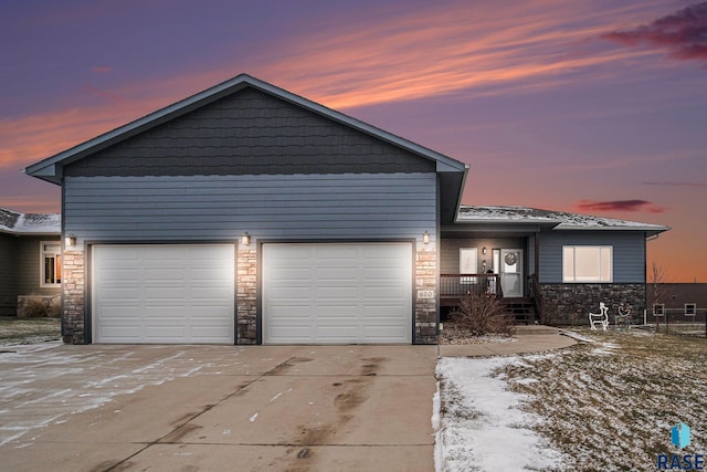 view of front of home with stone siding, concrete driveway, and a garage