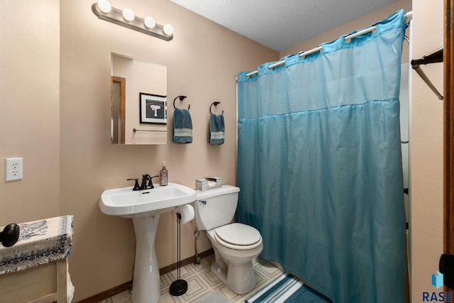 full bath with baseboards, toilet, curtained shower, tile patterned flooring, and a sink