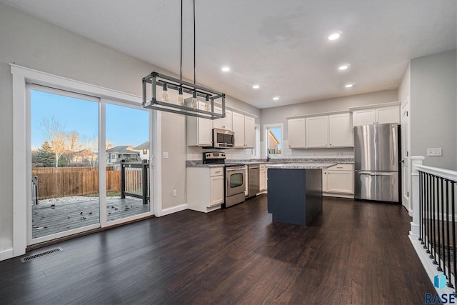 kitchen featuring appliances with stainless steel finishes, white cabinets, visible vents, and dark wood finished floors