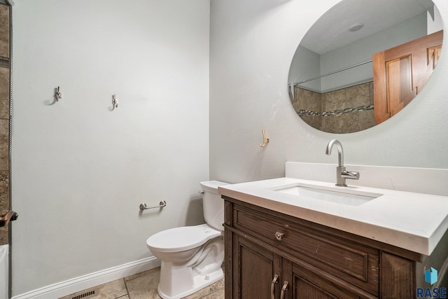 bathroom with baseboards, vanity, toilet, and tile patterned floors