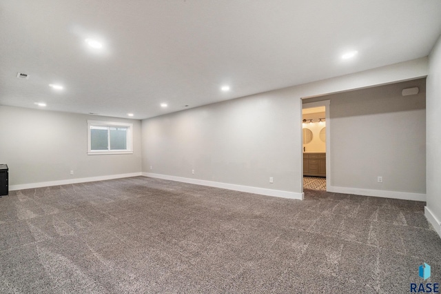 spare room with dark colored carpet, baseboards, and recessed lighting