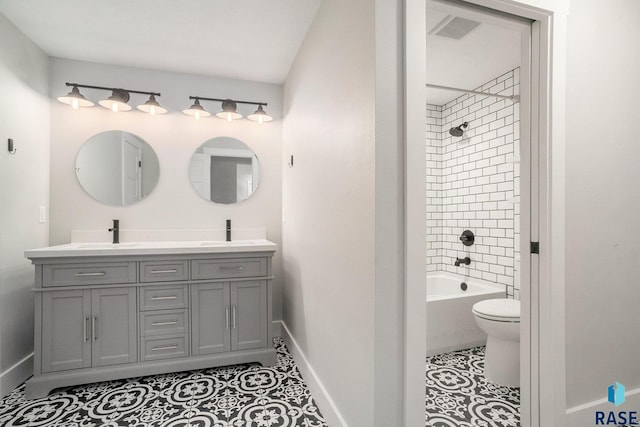 full bath with double vanity, toilet, a sink, baseboards, and tile patterned floors