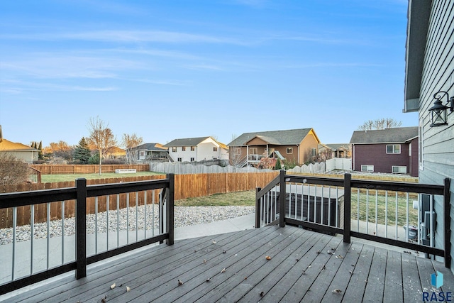 wooden deck featuring a residential view and a fenced backyard